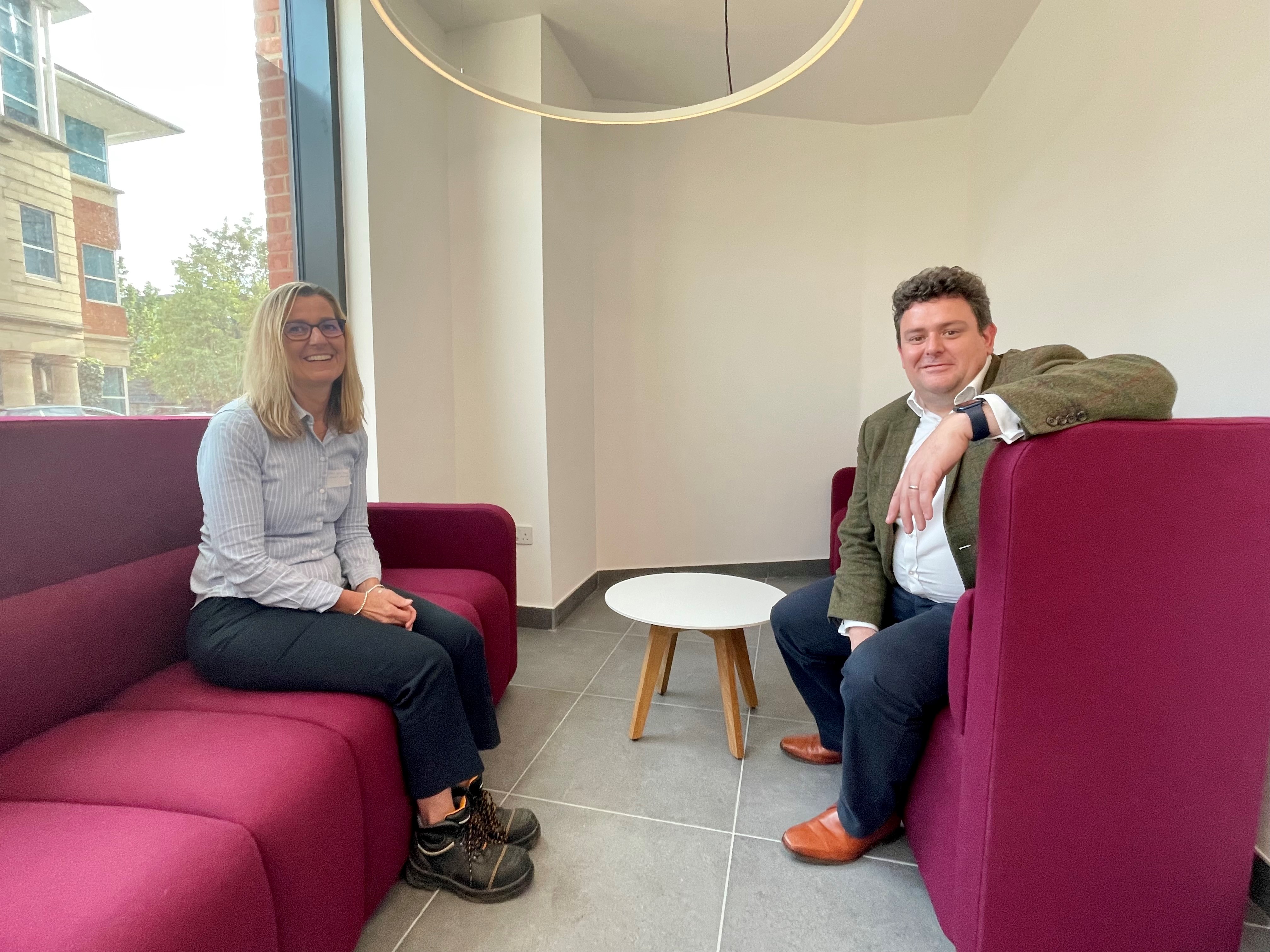 A picture of Alex Williams, Corporate Head of Assets and Regeneration at Runnymede Borough Council and Cllr Nick Prescot, leader of Runnymede Council sat on two purple sofas.