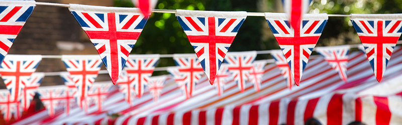Union Jack bunting across a street and above a red and white canopy