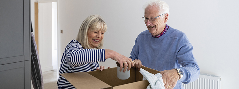 Two people packing a box