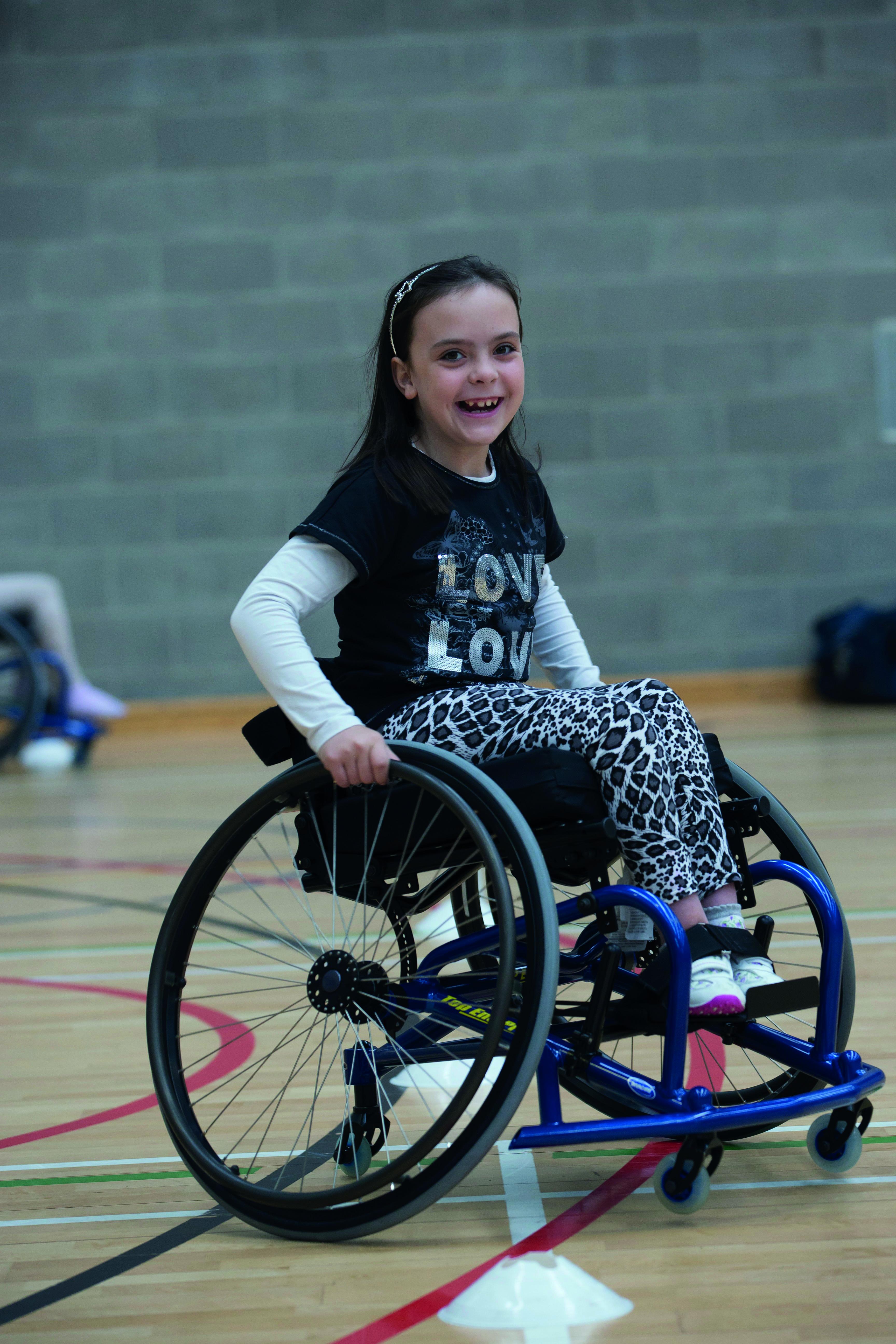 A girl in a wheelchair playing basketball